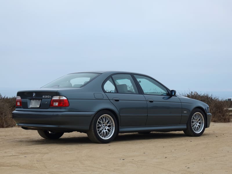 Rear three-quarter view of the BMW 530i sedan showing the 530i badge and BBS-style wheels