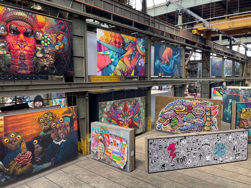 Large colorful street-art paintings displayed inside an industrial hall in Copenhagen